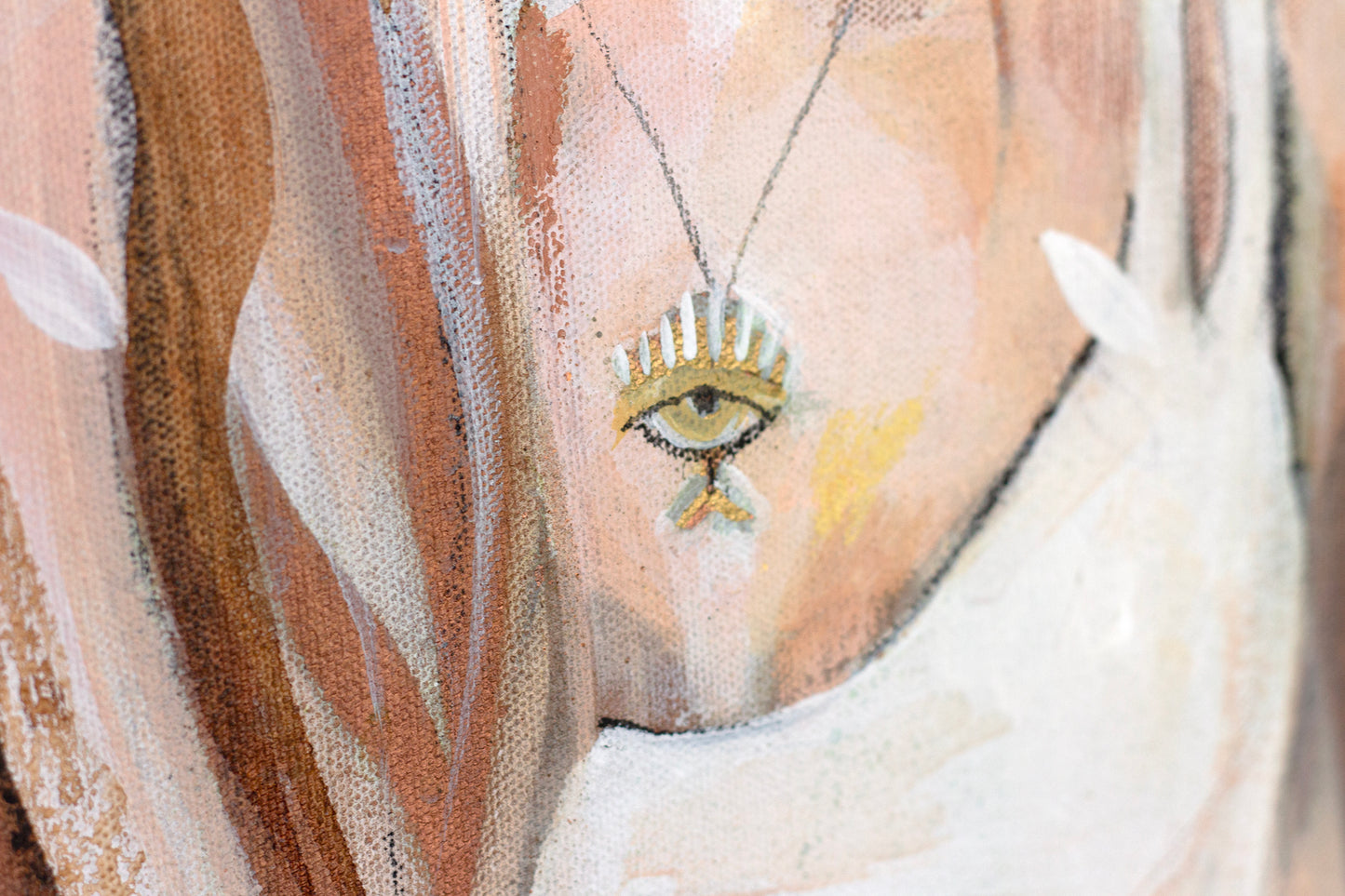 Close up detail of a necklace of and eye painted in gold. Bohemian style.