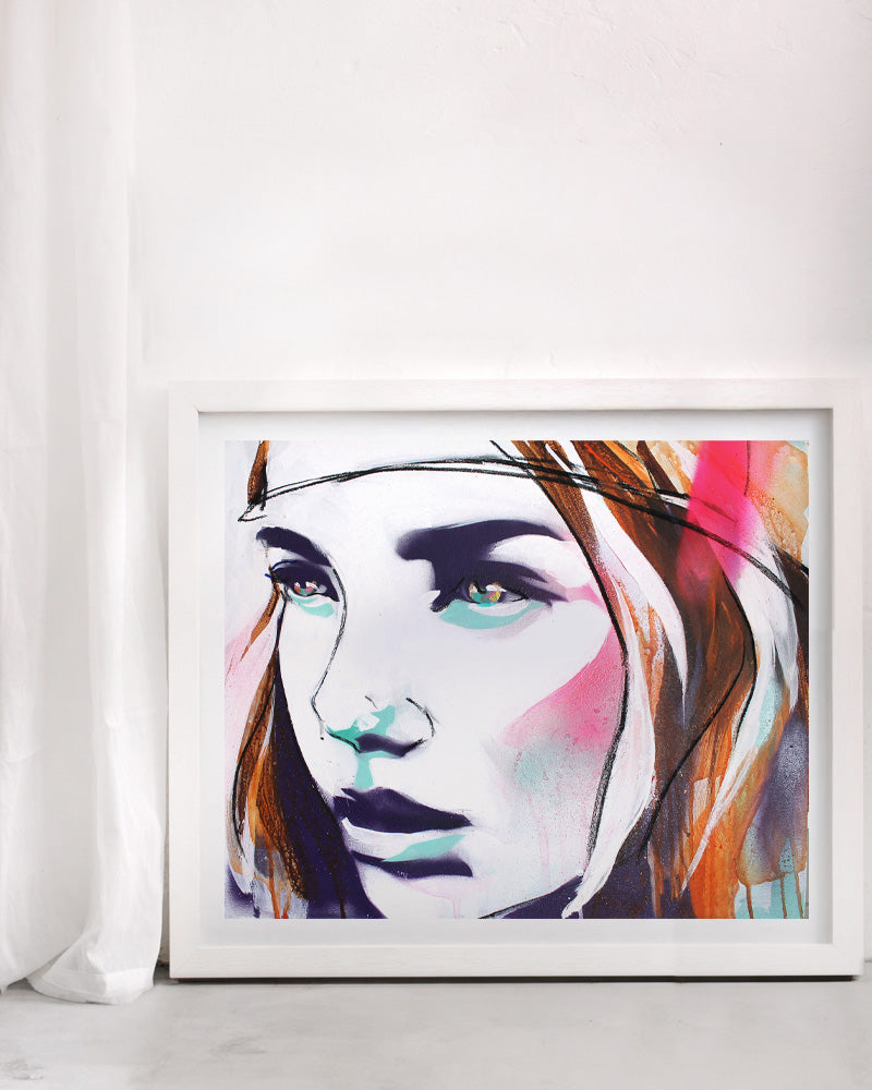 Neon portrait print of a woman in a street art style. In a white frame on a white wall