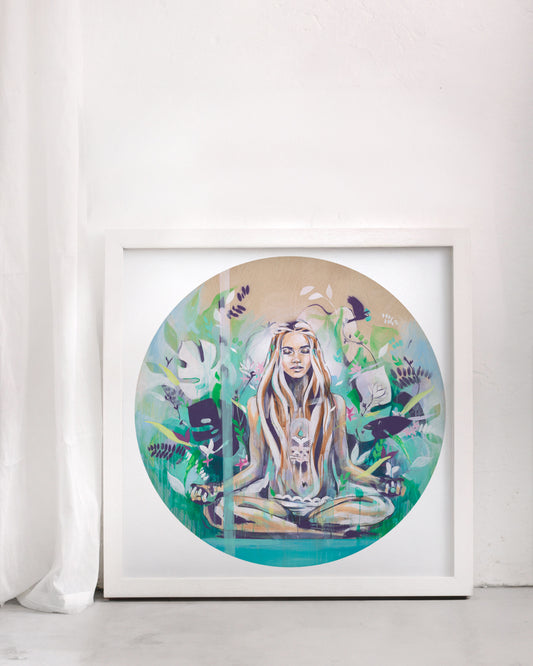 Yoga meditation print of a woman surrounded by green and turquoise. In a white frame in a white room.