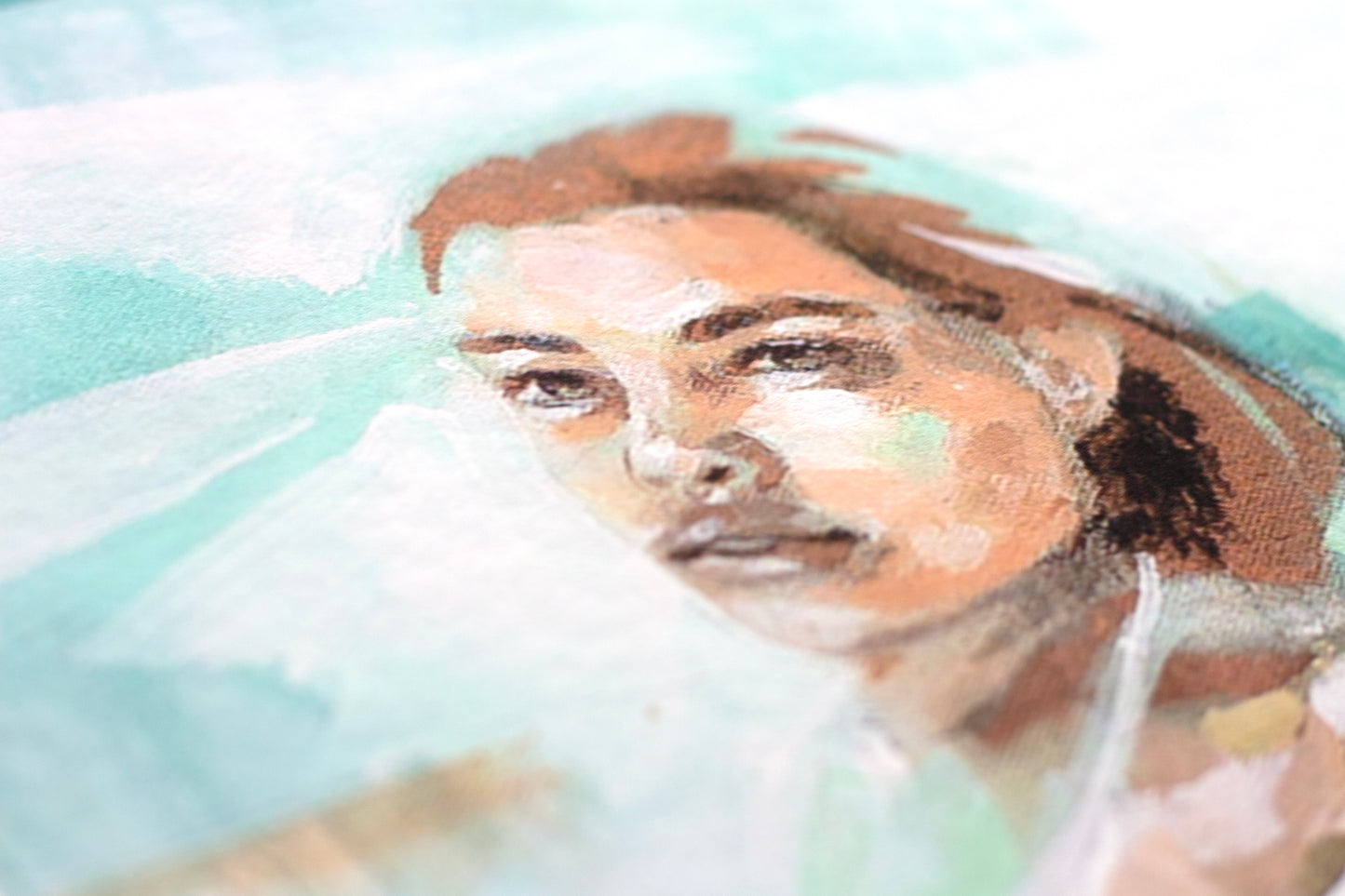 Close up detail of an art print, the face of a woman floating in the sea.
