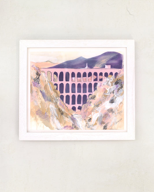 Nerja Aqueduct painted in pink and pastel tones. Framed in a white frame on a white wall.