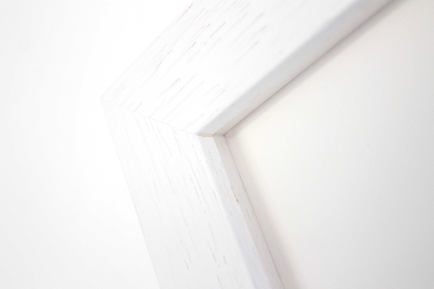 close up detail of a white box frame with wood grain.