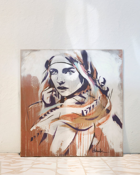 Wild bohemian portrait painting of a girl in earthy tones. The painting is leaning against the wall in a Mediterranean style interior.