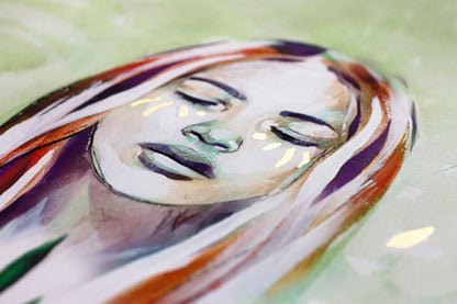 Close up detail of art print of a girls face with gold leaf.