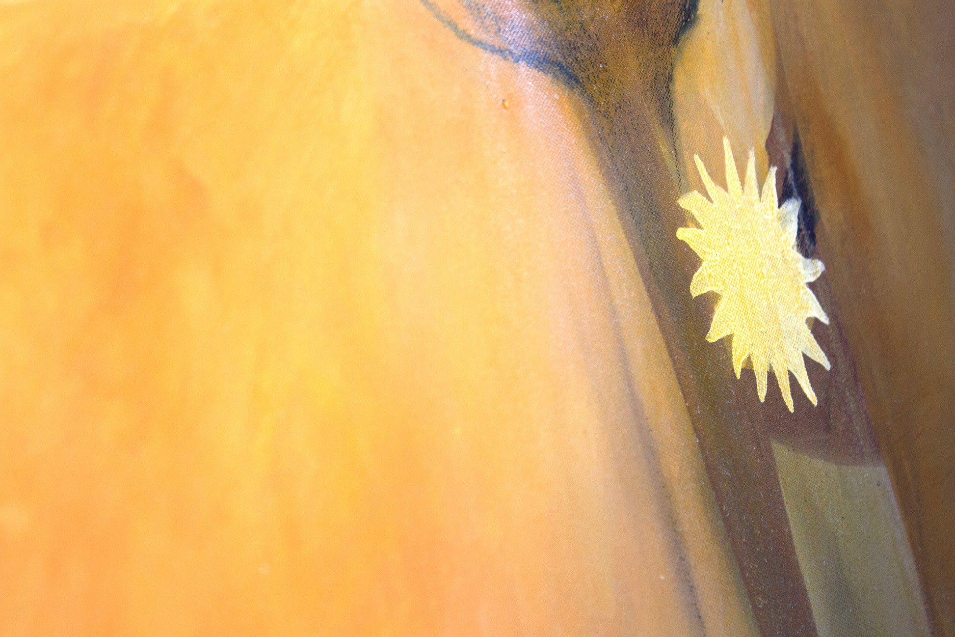 Close up detail of a painting in an orange glow. A sun earring detail.