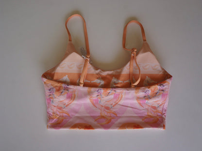 Flatlay of the back of the Chasing Rivers x Hannah Chloe Calypso pink illustrated crop top with adjustable straps and soft peach and pink artwork.