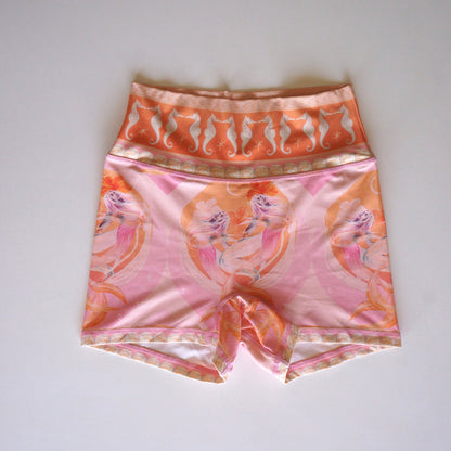 Calypso high-waist shorts by Chasing Rivers featuring Hannah Chloe’s mermaid and seahorse artwork in soft pink and peach tones, laid flat on white background.