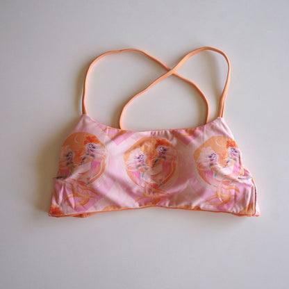 Flatlay of the Chasing Rivers x Hannah Chloe Calypso pink illustrated crop top featuring soft feminine artwork in peach and pink tones on a white background.