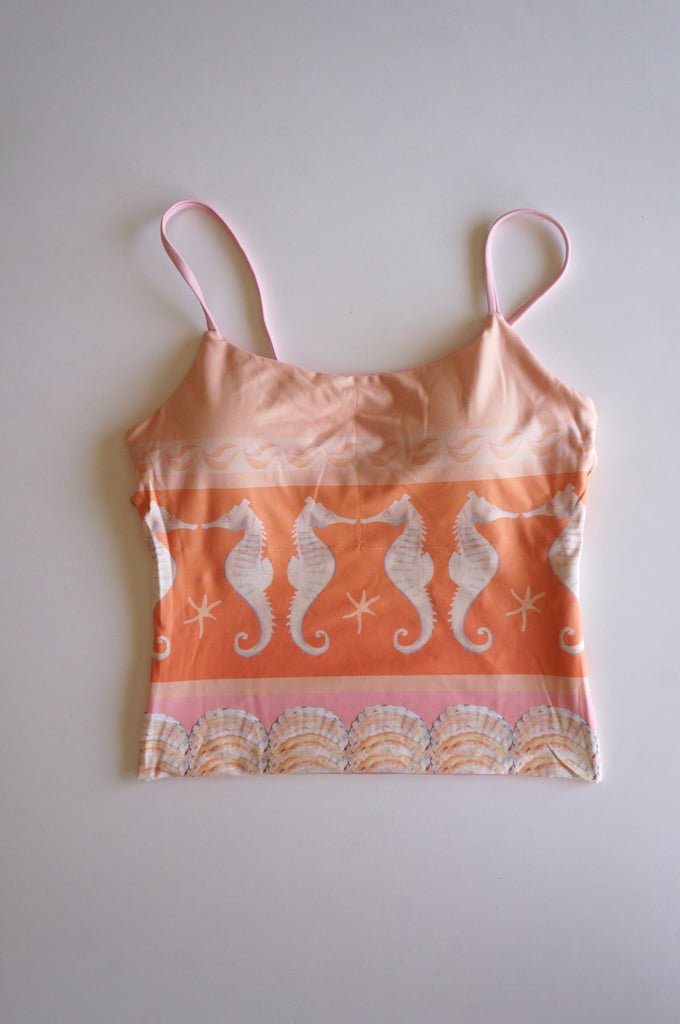 Flatlay of the Chasing Rivers x Hannah Chloe pink and orange cami featuring a repeating seahorse pattern, seashell border, and soft coastal-inspired artwork.