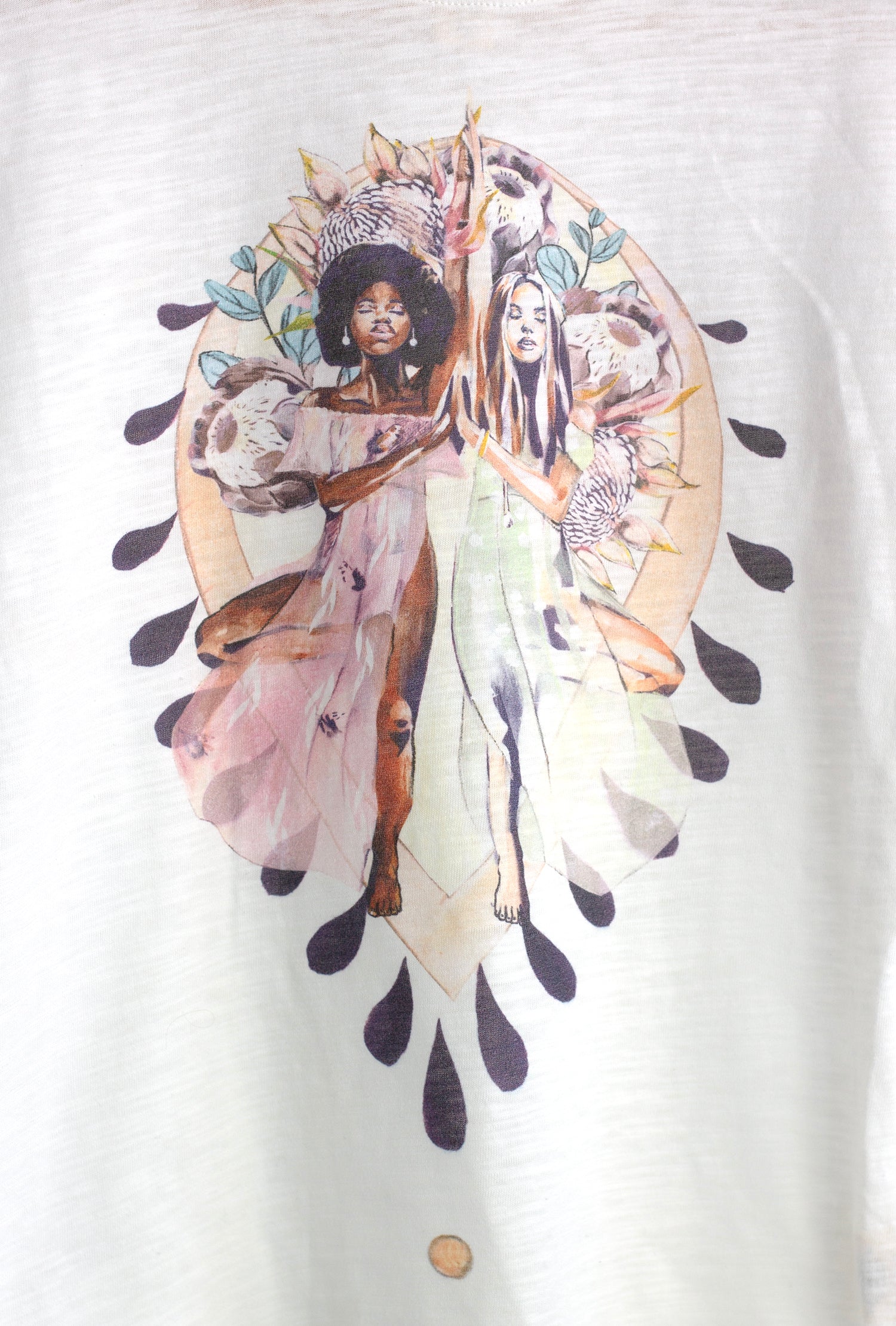 Close-up of the Grounded t-shirt artwork by Studio Hannah Chloe, featuring two women in yoga tree pose surrounded by floral and earth-inspired details.