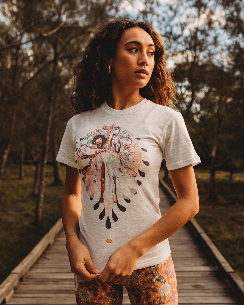 Woman wearing the Grounded organic cotton t-shirt by Studio Hannah Chloe, featuring an art-inspired yoga print, photographed outdoors in soft natural light.